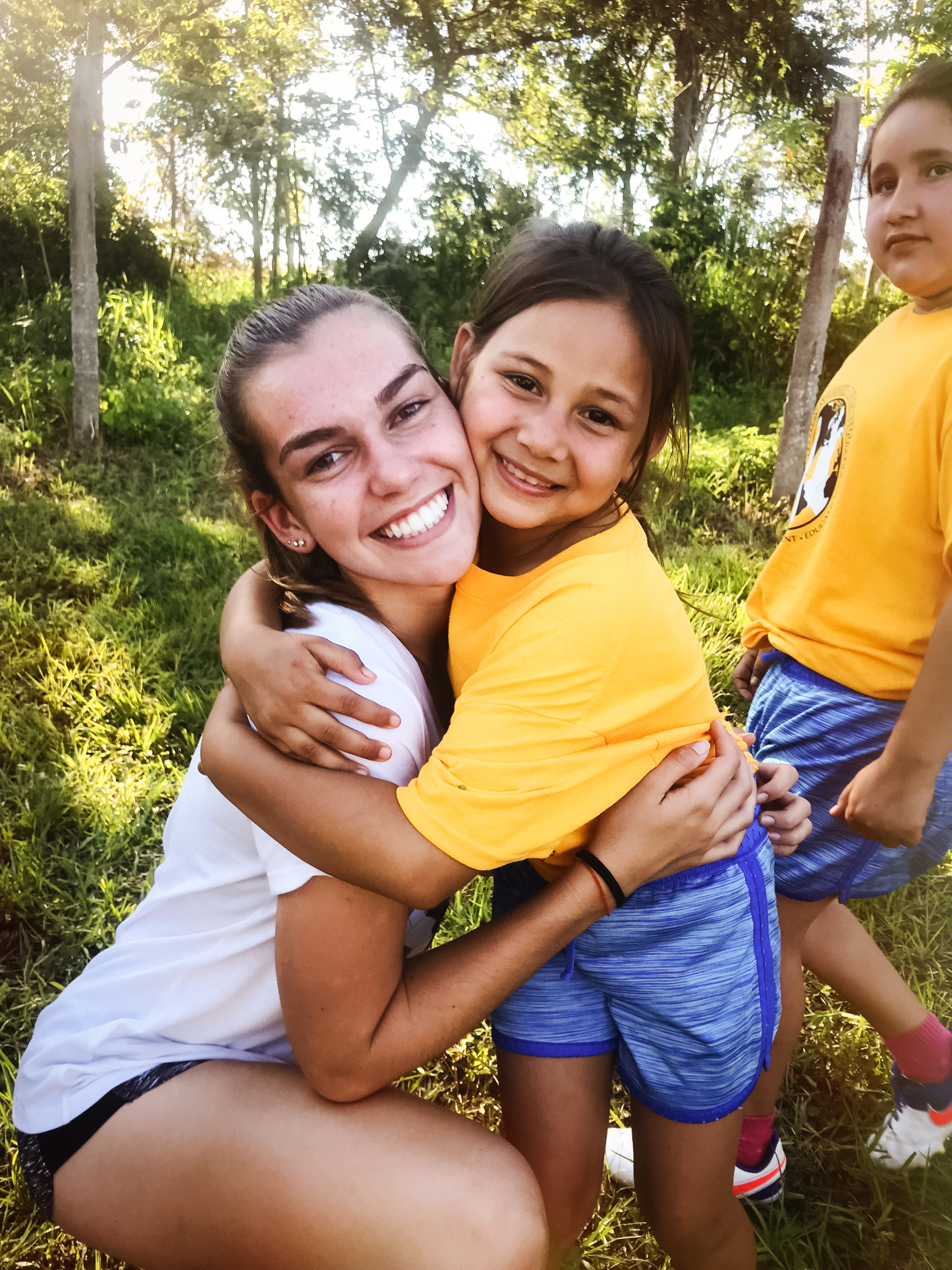 Emily embracing love with a young girl at a Girls Soccer Worldwide partnered school during her 2018 trip to Paraguay.